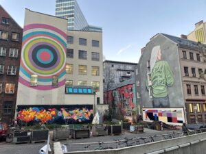Blick auf das Gebäude der Fabrique im Gängeviertel, verschiedene Wandbemalungen (bunte Kreise und eine Frau von Hinten)